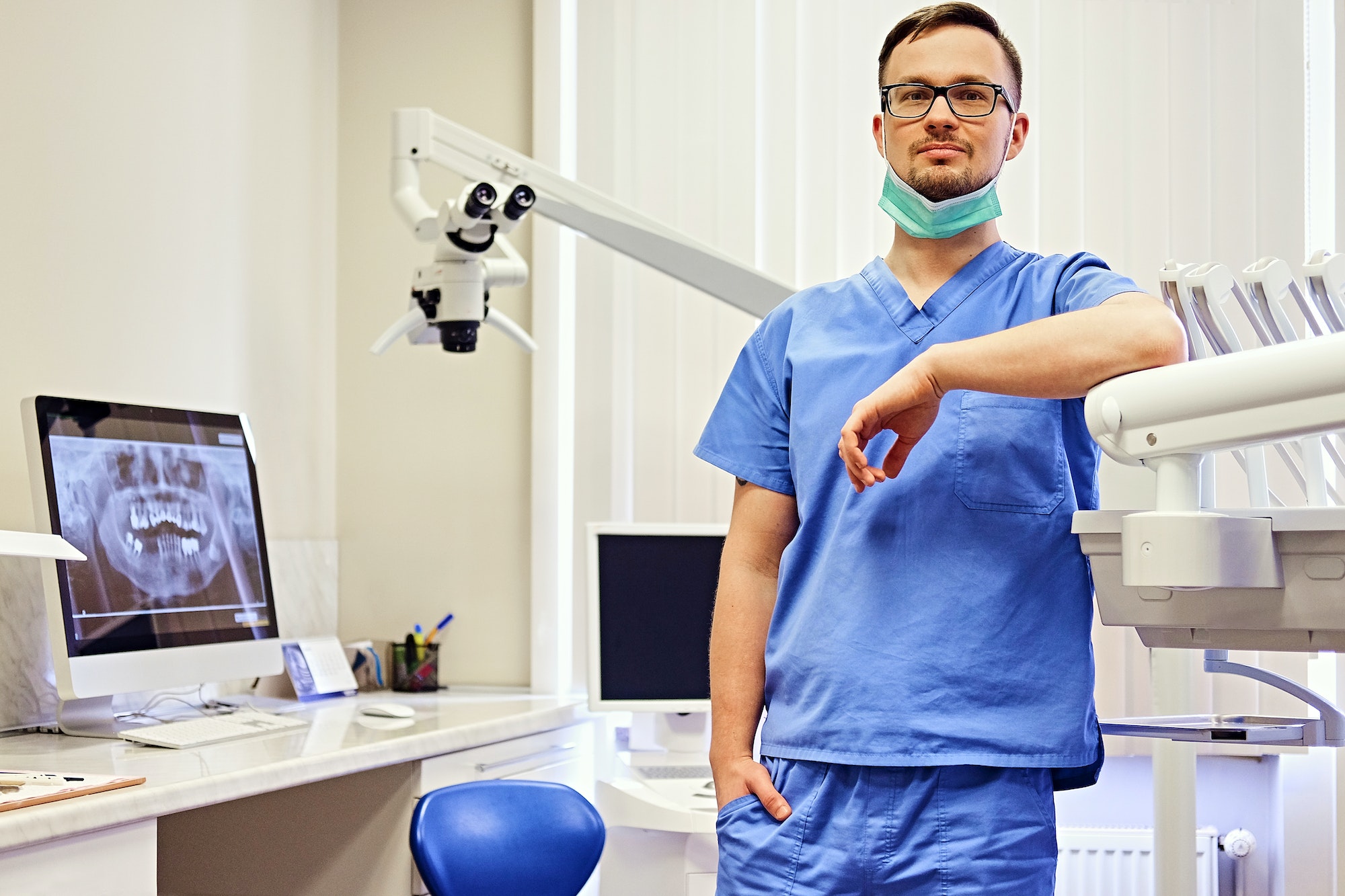 Dentist in a room with medical equipment on background.